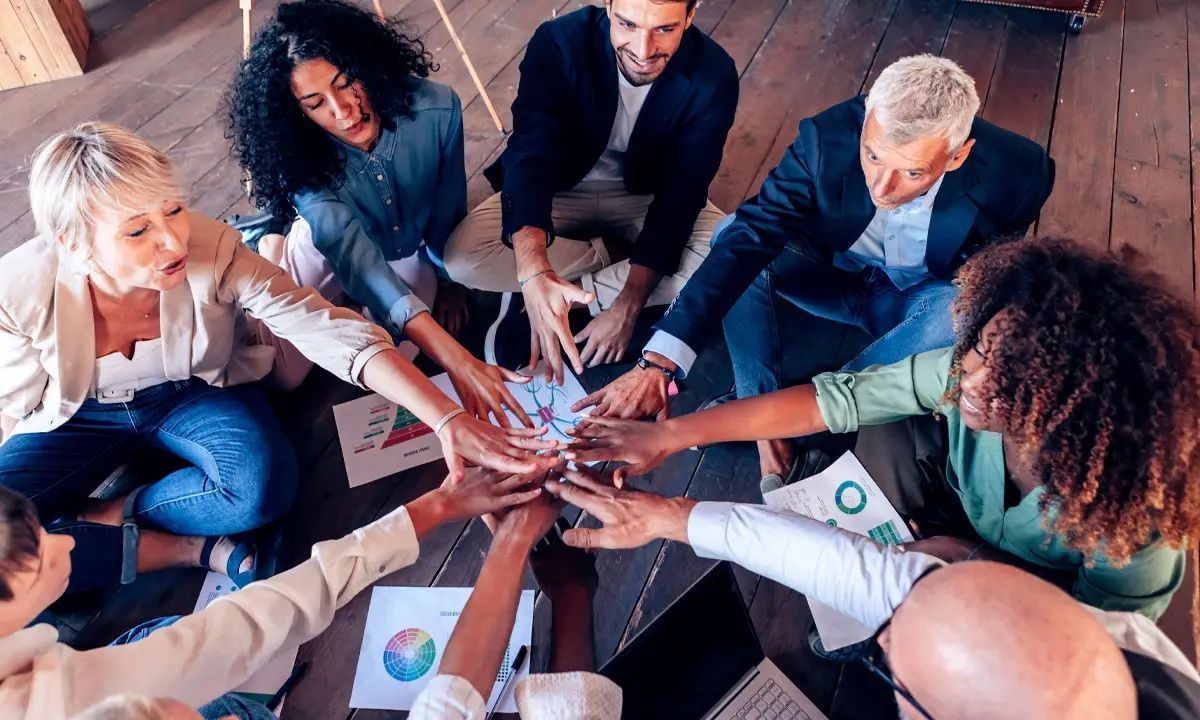 Imagen que muestra un grupo de personas con sus manos entrelazadas para la sección del botón de formación presencial de Somatic Experiencing